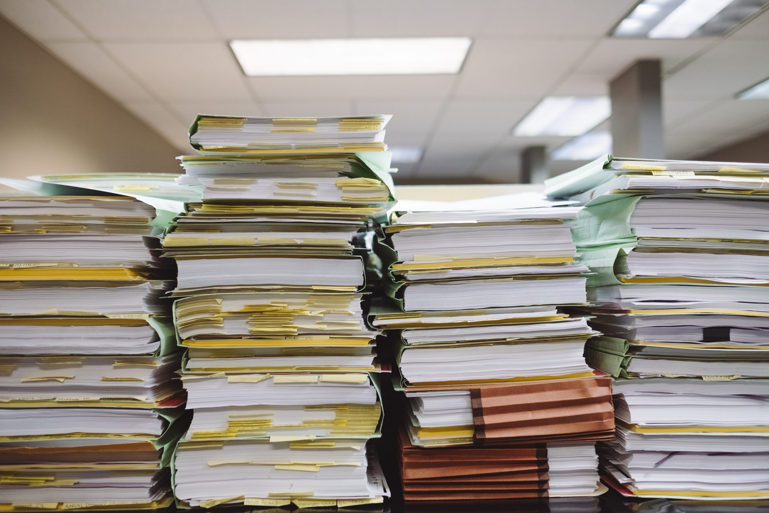 Photo of disorganized stacks of paper and folders